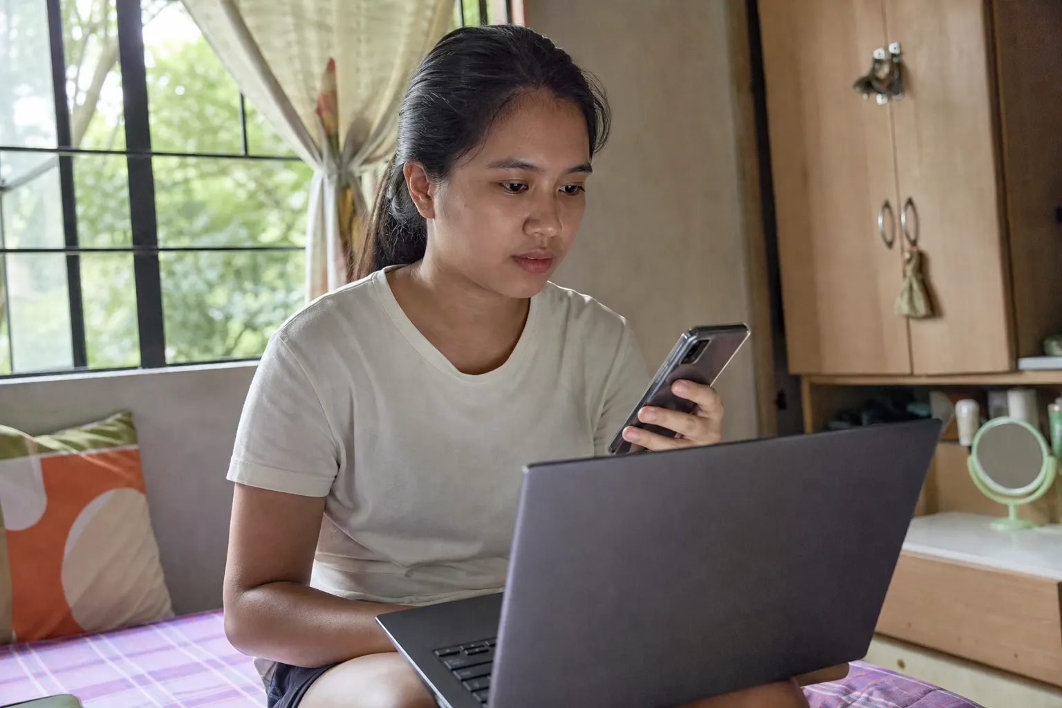 Young Filipina student with laptop, starting from Medical Billing basics.